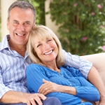 Senior Couple Relaxing On Sofa At Home