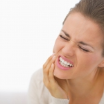 Portrait of young woman with toothache